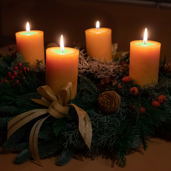 Adventskranz mit vier brennenden Kerzen (orange)