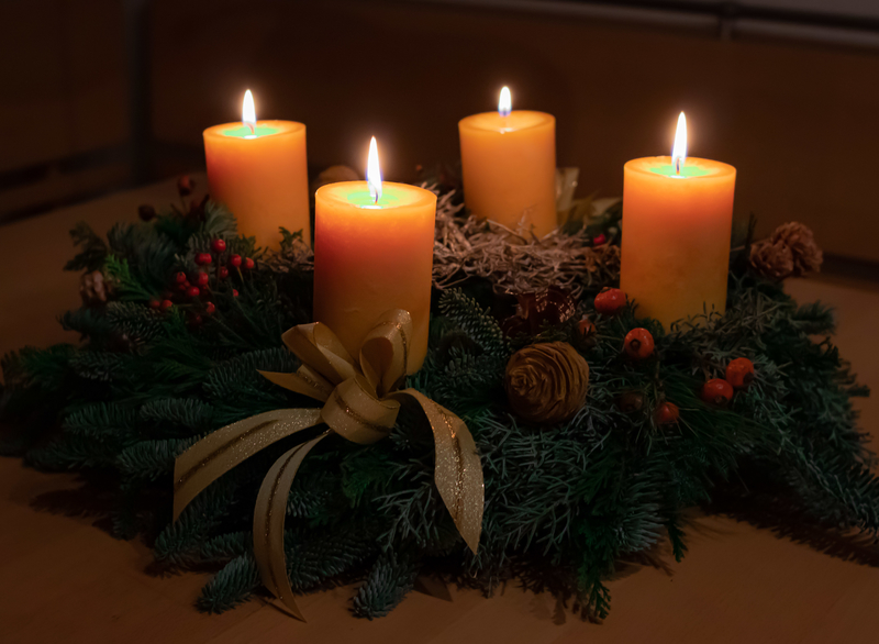 Adventskranz mit vier brennenden Kerzen (orange)