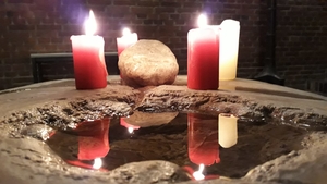 Taufstein mit Kerze in der Kirche St. Vinzenz Klettham
